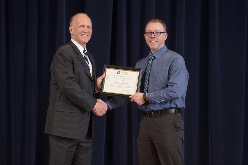 Doctor Potteiger posing for a photo with an award recipient in a blue shirt and blue patterned tie